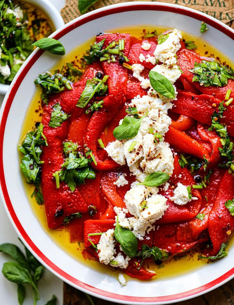 Geröstete rote Paprika mit Minos Natives Olivenöl Extra, verfeinert mit frischen Kräutern und zerbröseltem Feta-Käse – ein mediterraner Genuss.